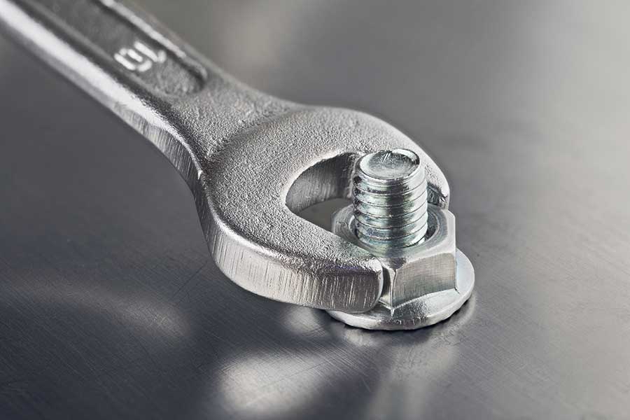 A wrench tightening a bolt with a washer.
