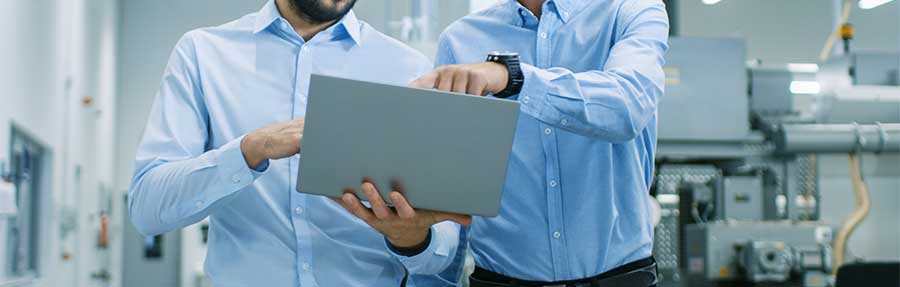Close-up of two engineers looking at a tablet computer.